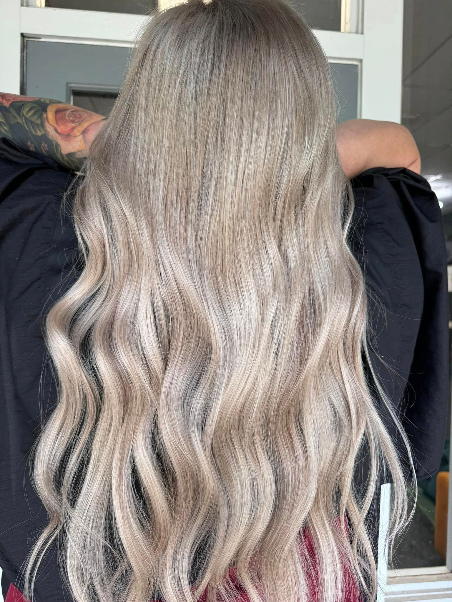 Long icy blonde hair with dimensional highlights and soft waves in Springfield, MO.
