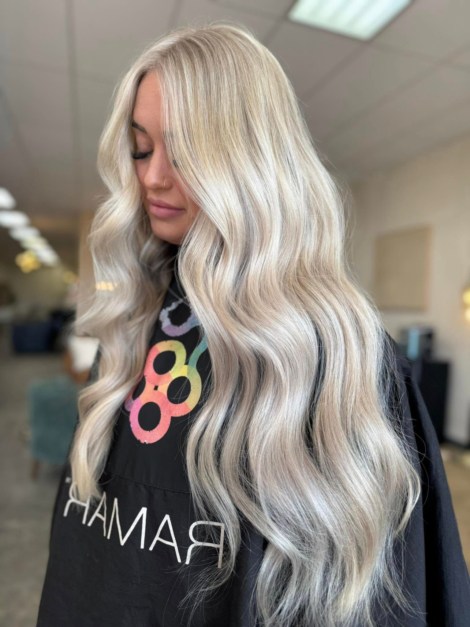Long platinum blonde hair with dimensional color and soft waves by a blonde specialist near Branson, MO.