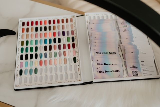 Nail color options in a book at top nail salon for gel x and acrylic nails in Springfield MO