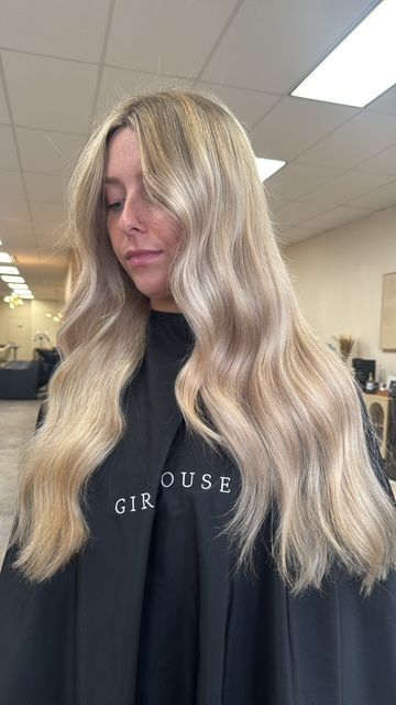 Long dimensional blonde hair with natural-looking highlights and soft waves in Strafford, MO.