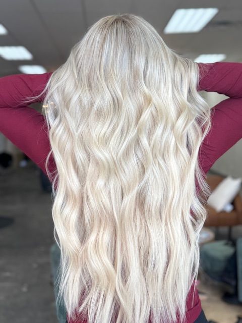 Long platinum blonde hair extensions blended for added length and volume in Ozark, MO.
