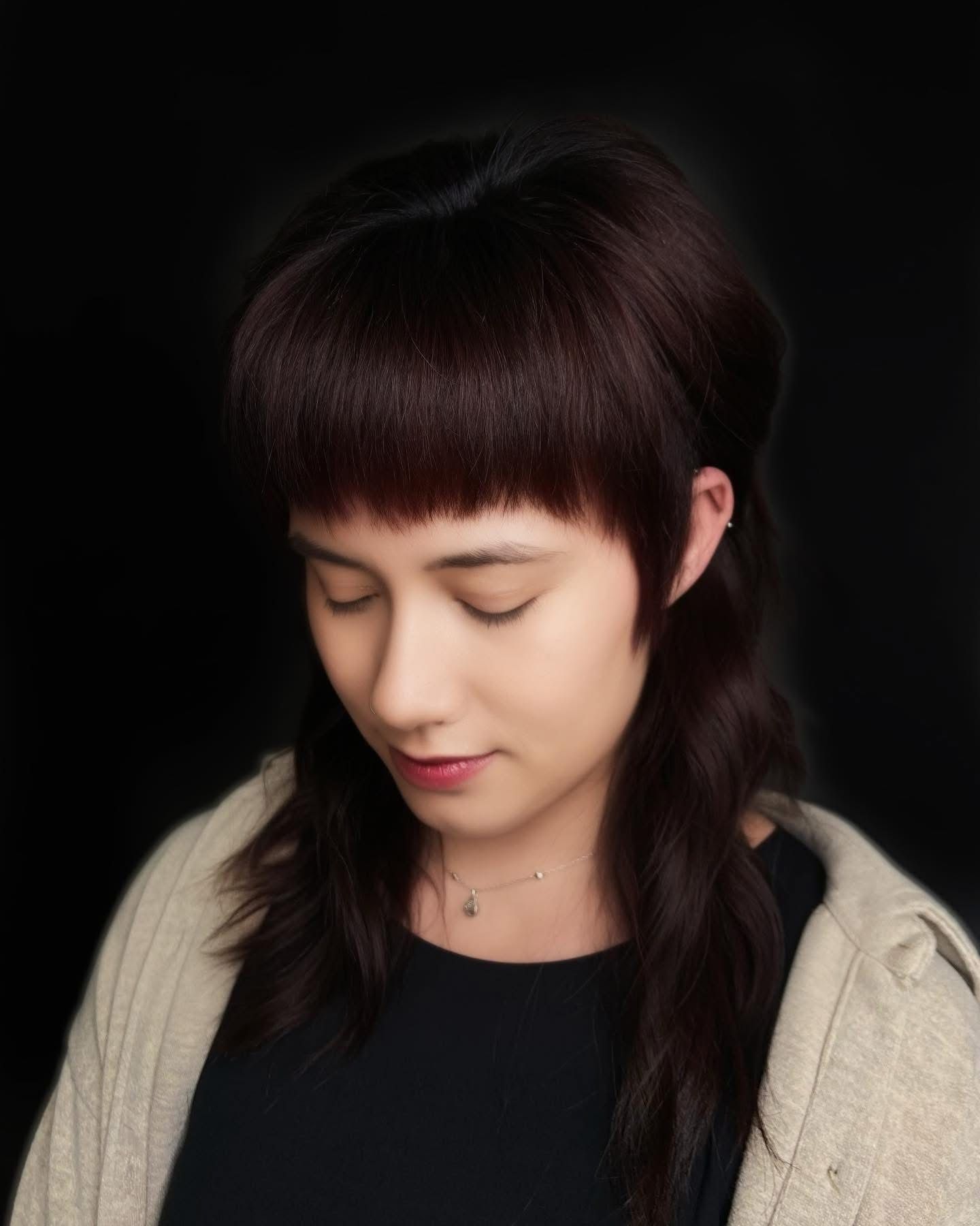 woman looking down with dark fashion hair cut in springfield mo