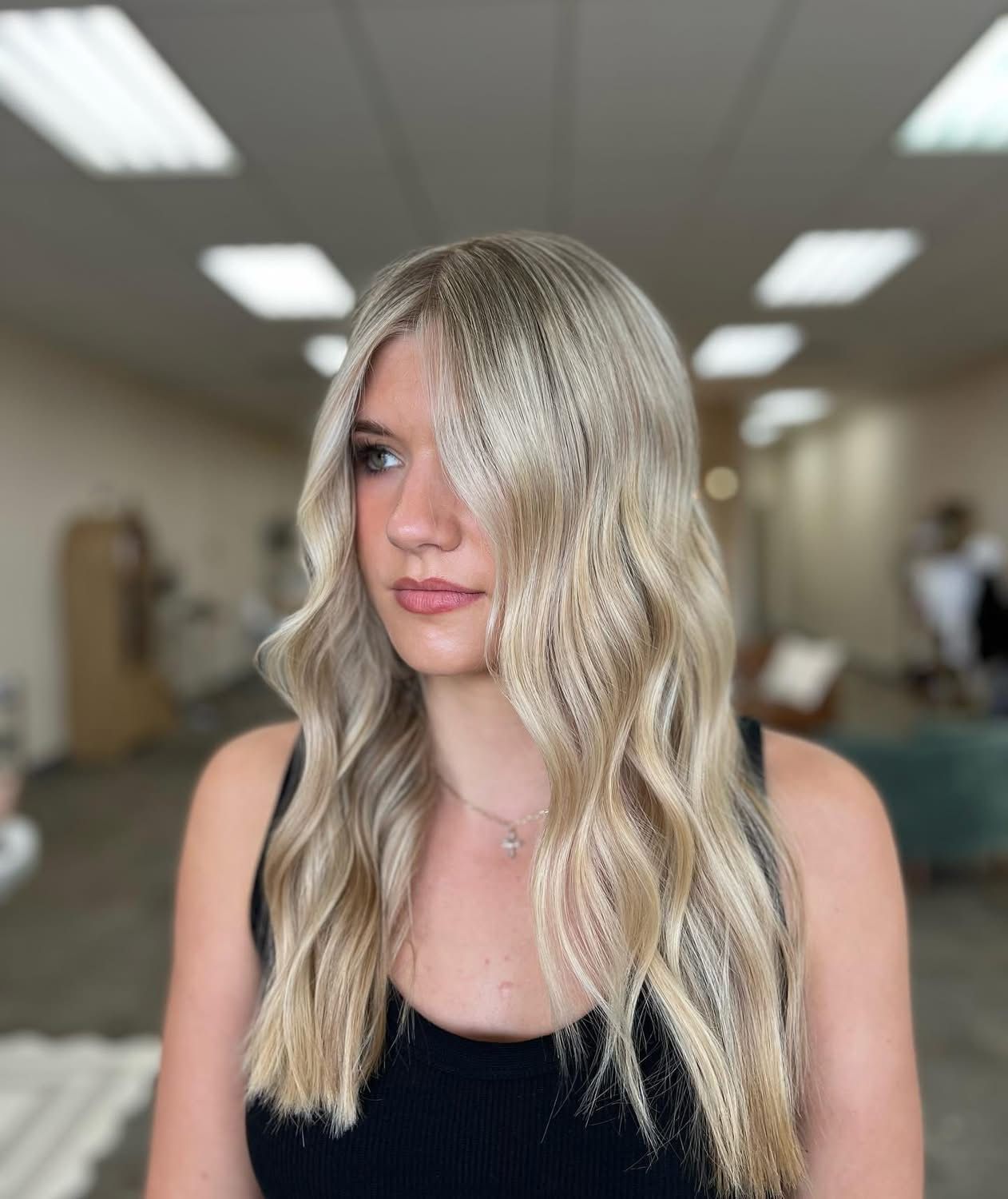 Long dimensional blonde hair with soft waves created by a blonde specialist in Nixa, MO.