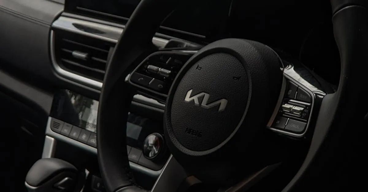 Close-up of a Kia car steering wheel with controls and the KIA logo, set inside a vehicle.