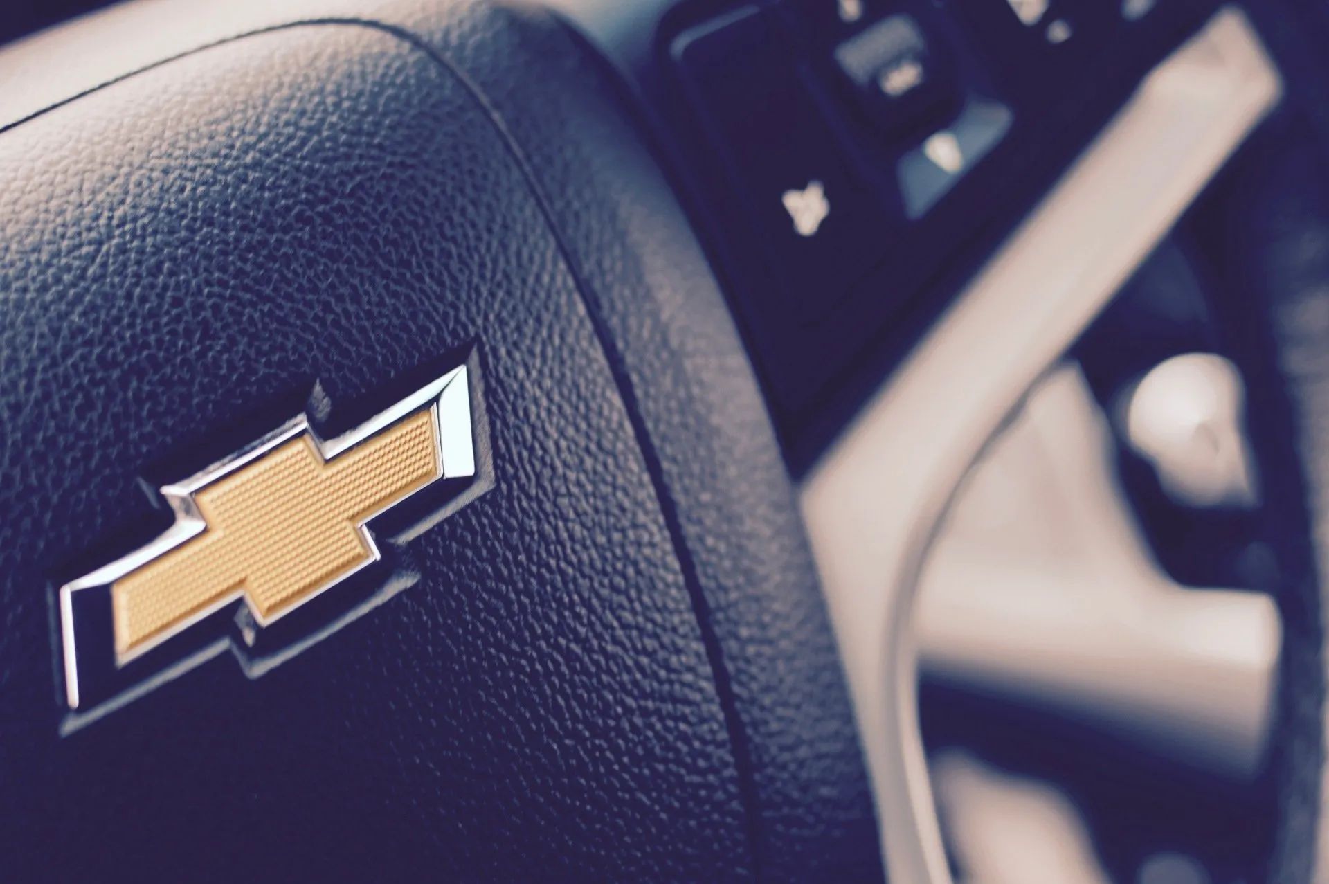 Chevrolet logo on a black steering wheel, close-up.