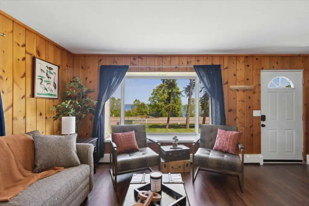 A living room with wood paneling and a large window