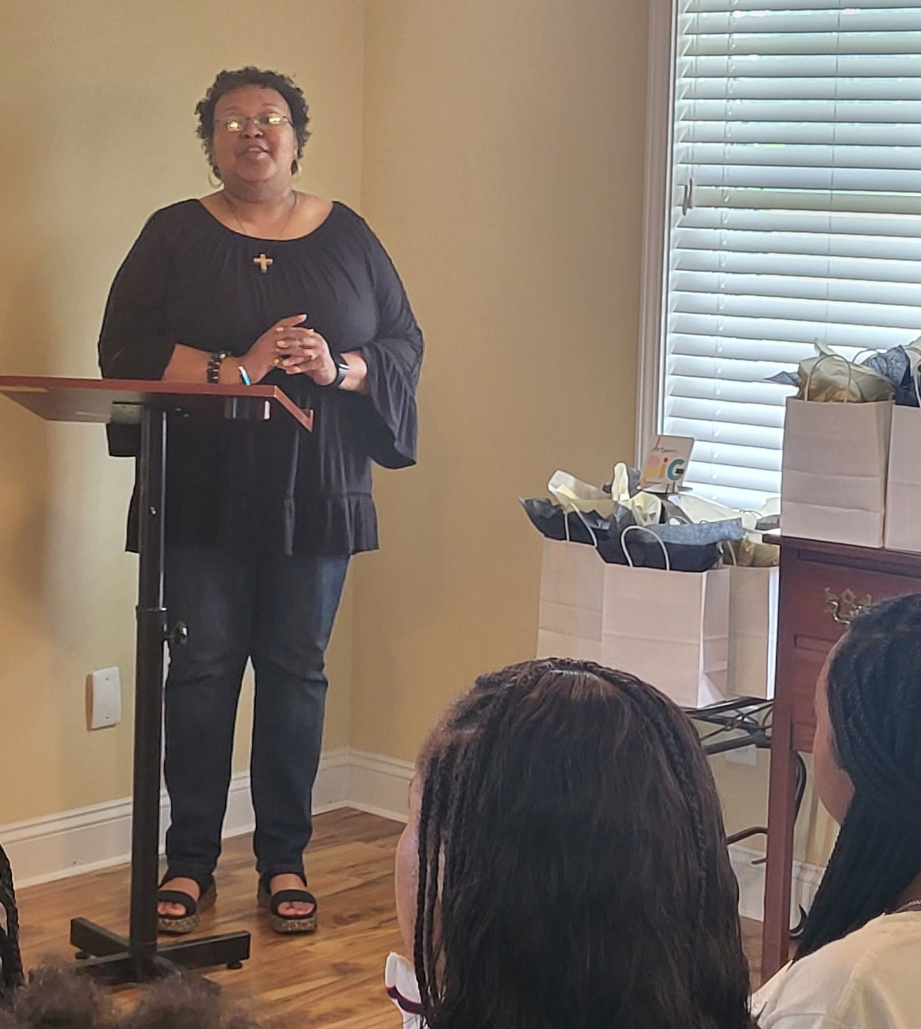 A woman is standing at a podium in front of a group of people.