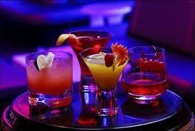A table with four different colored drinks on it