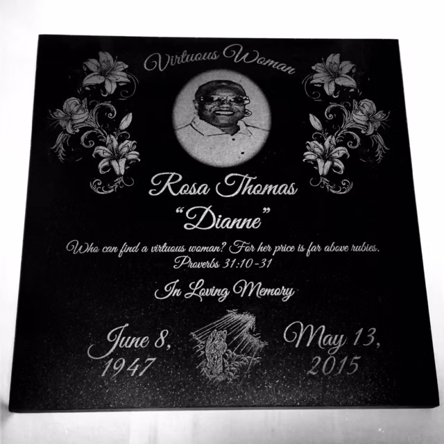 Memorial plaque with portrait, flowers, and dates June 8, 1947 and May 13, 2015