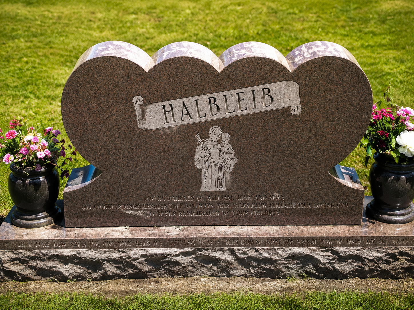 Gravestone with purple flowers in a cemetery lawn