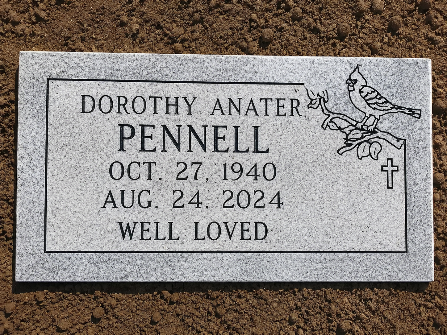 Gray gravestone for Dorothy Anater Pennell with dates Oct. 27, 1940 and Aug. 24, 2024, “Well Loved” and floral engraving