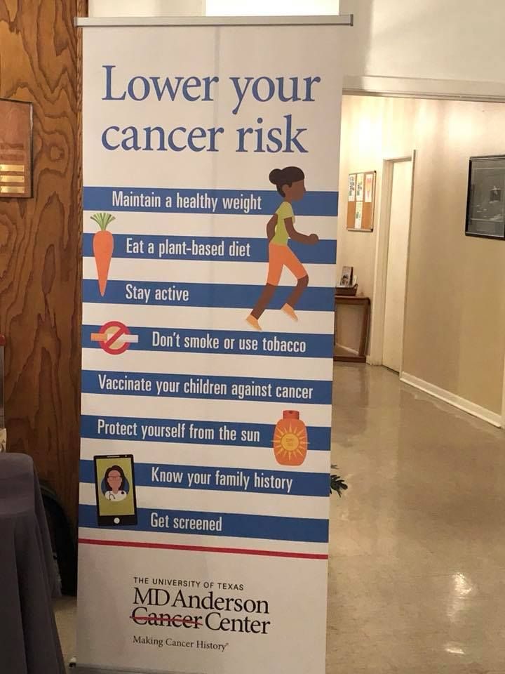 Cancer risk prevention banner in a lobby, listing healthy habits on a blue sign with the MD Anderson logo.
