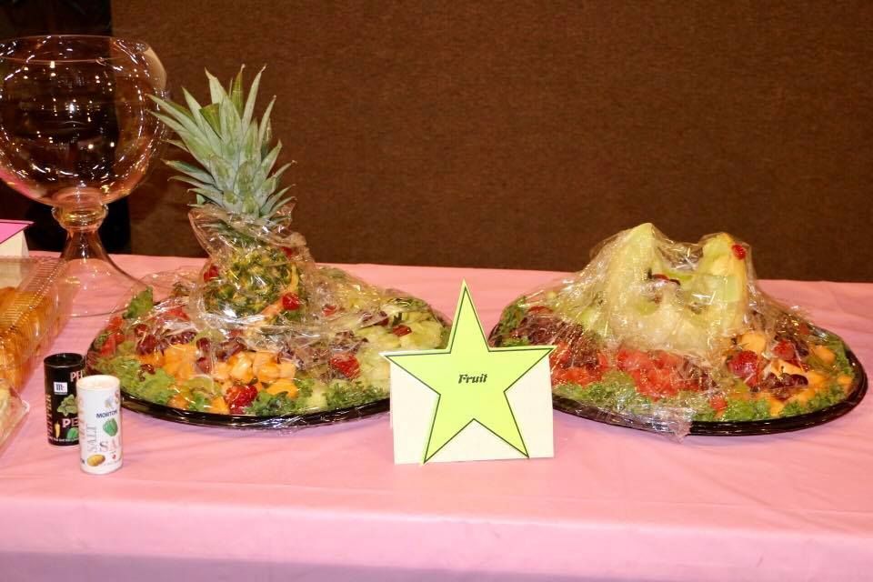Two decorated platters on a pink tablecloth with a star-shaped sign between them