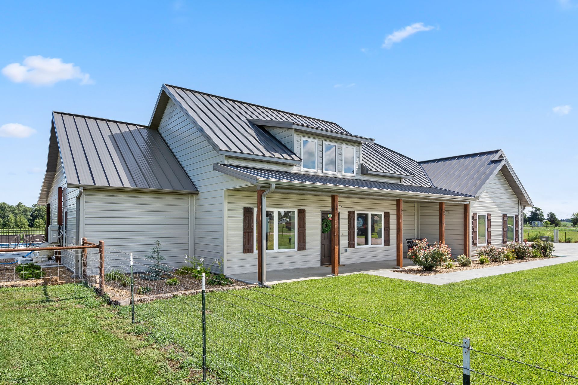 Completed custom ICF home with black, white, and red metal siding and an attached garage.