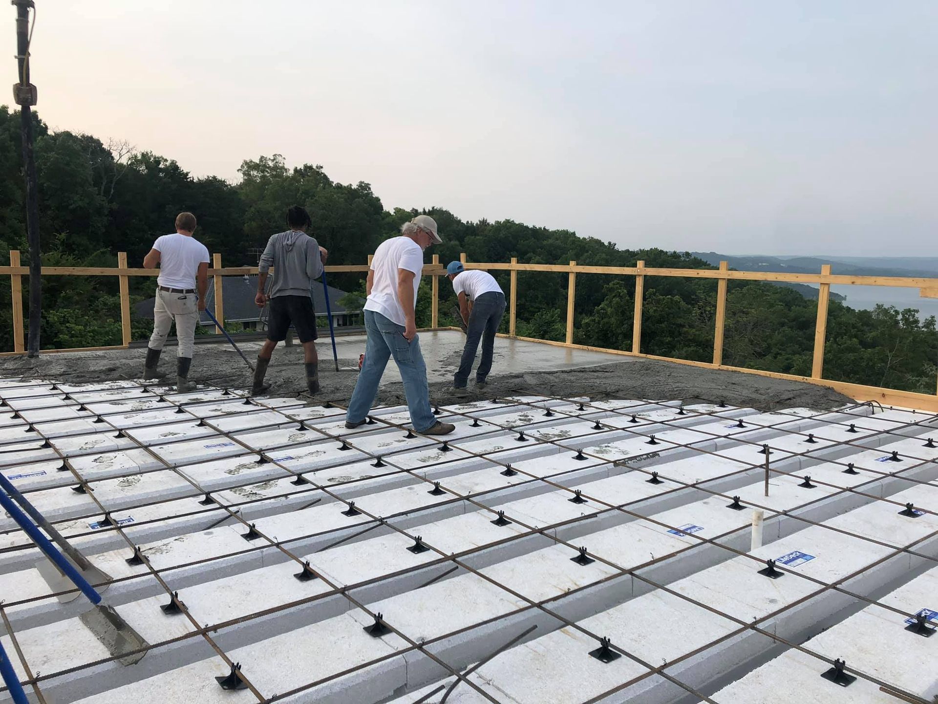ICF construction crew pouring concrete over insulated concrete forms for a custom home project.
