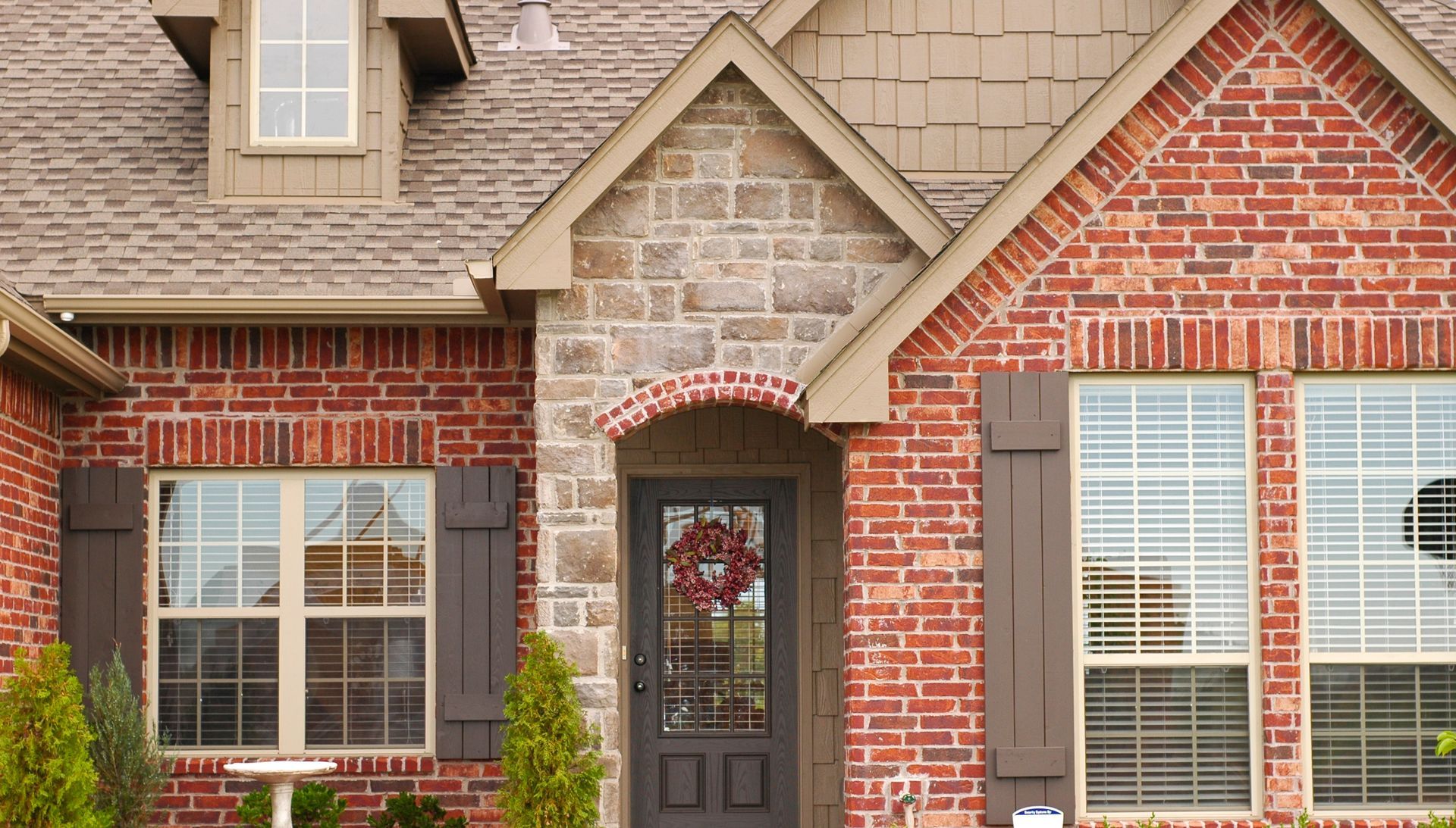 Red brick exterior with board and batten shutters on custom home | Rogersville, MO