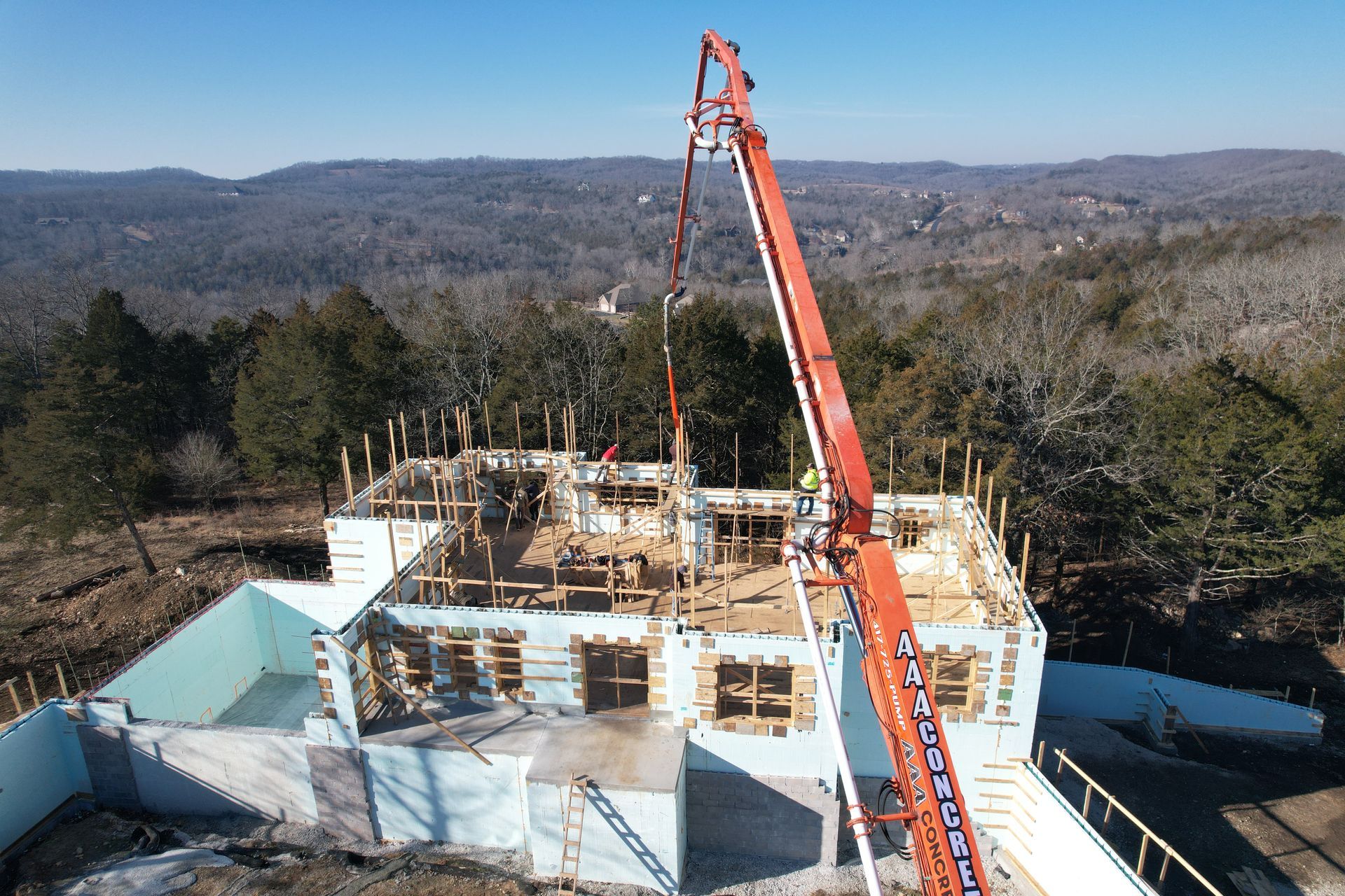 An aerial view of an ICF building under construction with a pump truck pouring concrete Rogers AR Builders