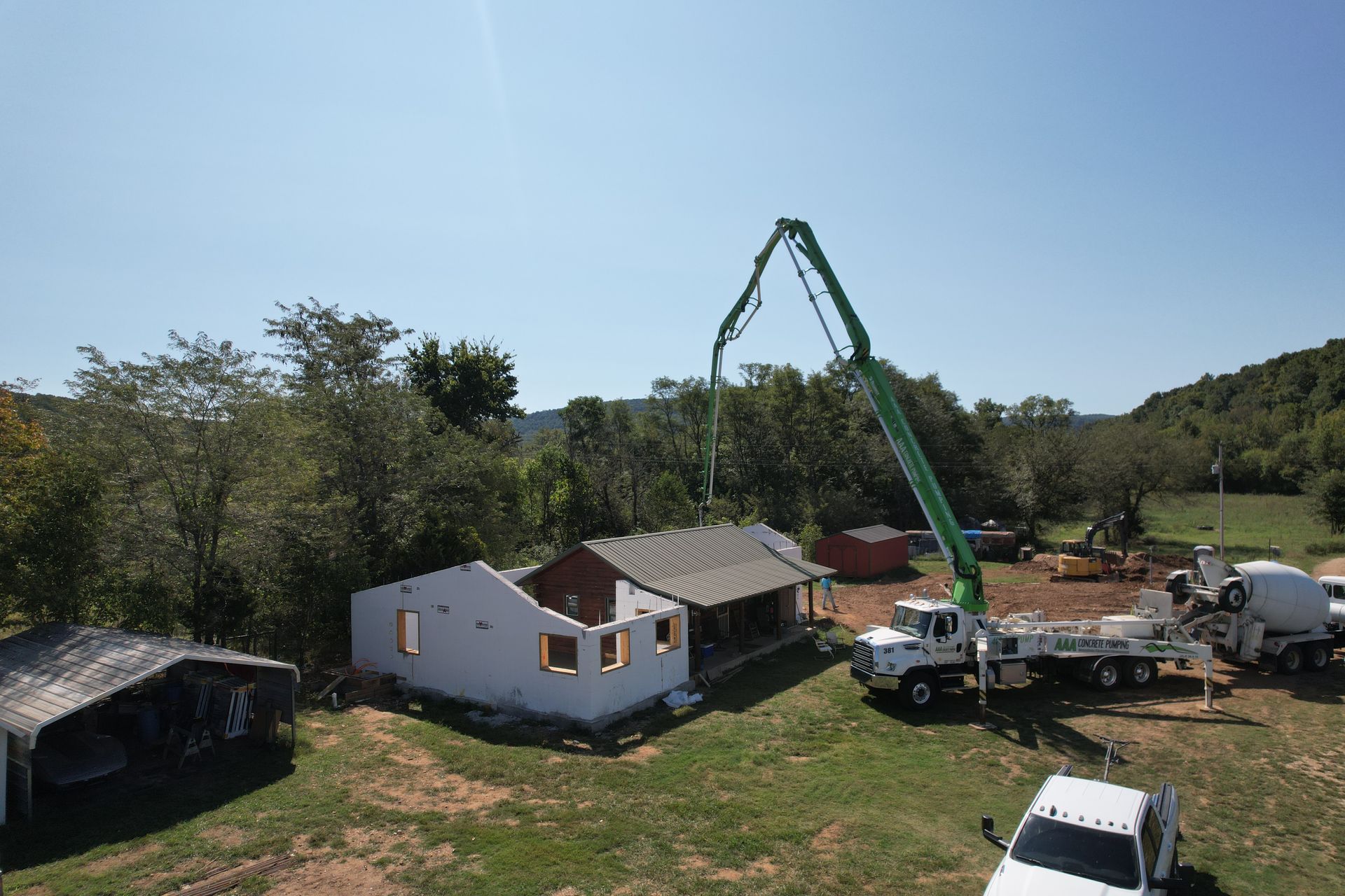 Concrete pump truck in front of log cabin and insulated concrete form home addition | Alpena, AR