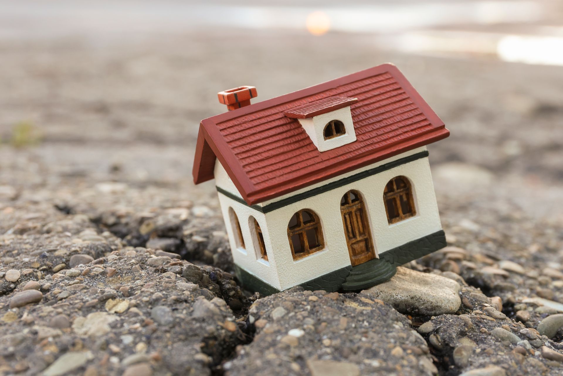 House model showing foundation cracks and ground shifting in spring conditions