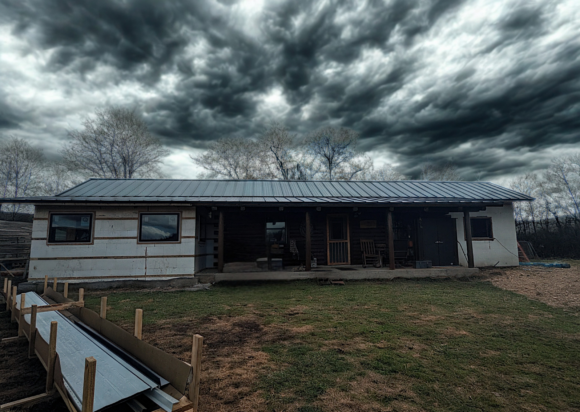 ICF home under construction in the Ozarks beneath dark storm clouds before severe weather