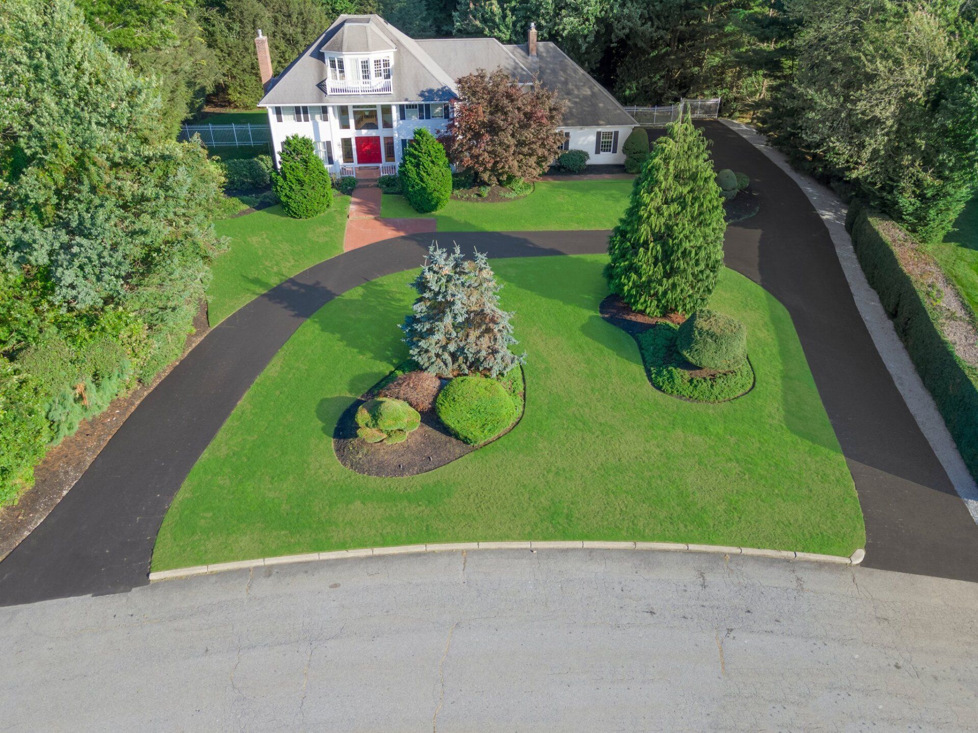 An aerial view of a house with a large driveway