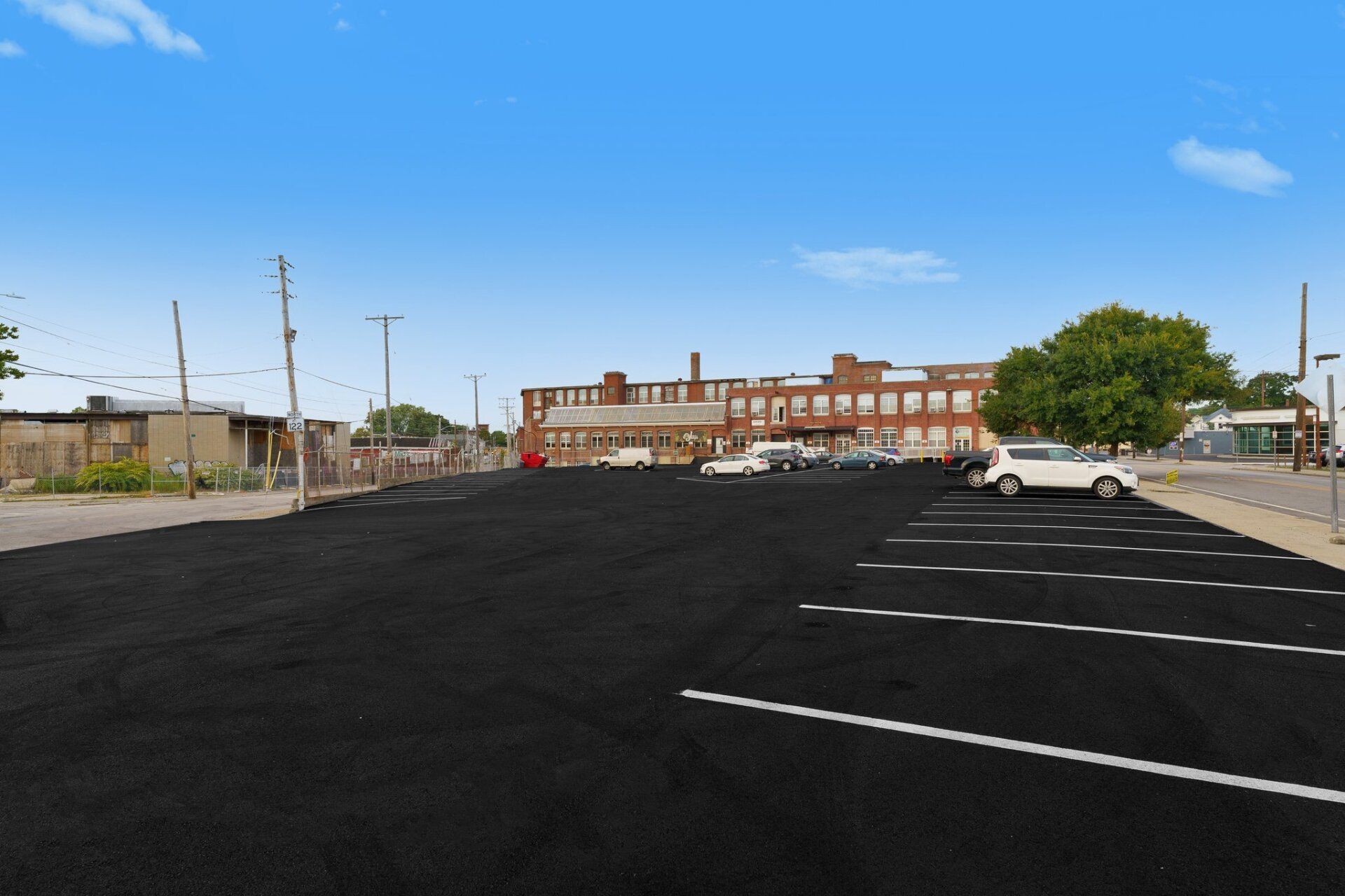 A large parking lot with a brick building in the background