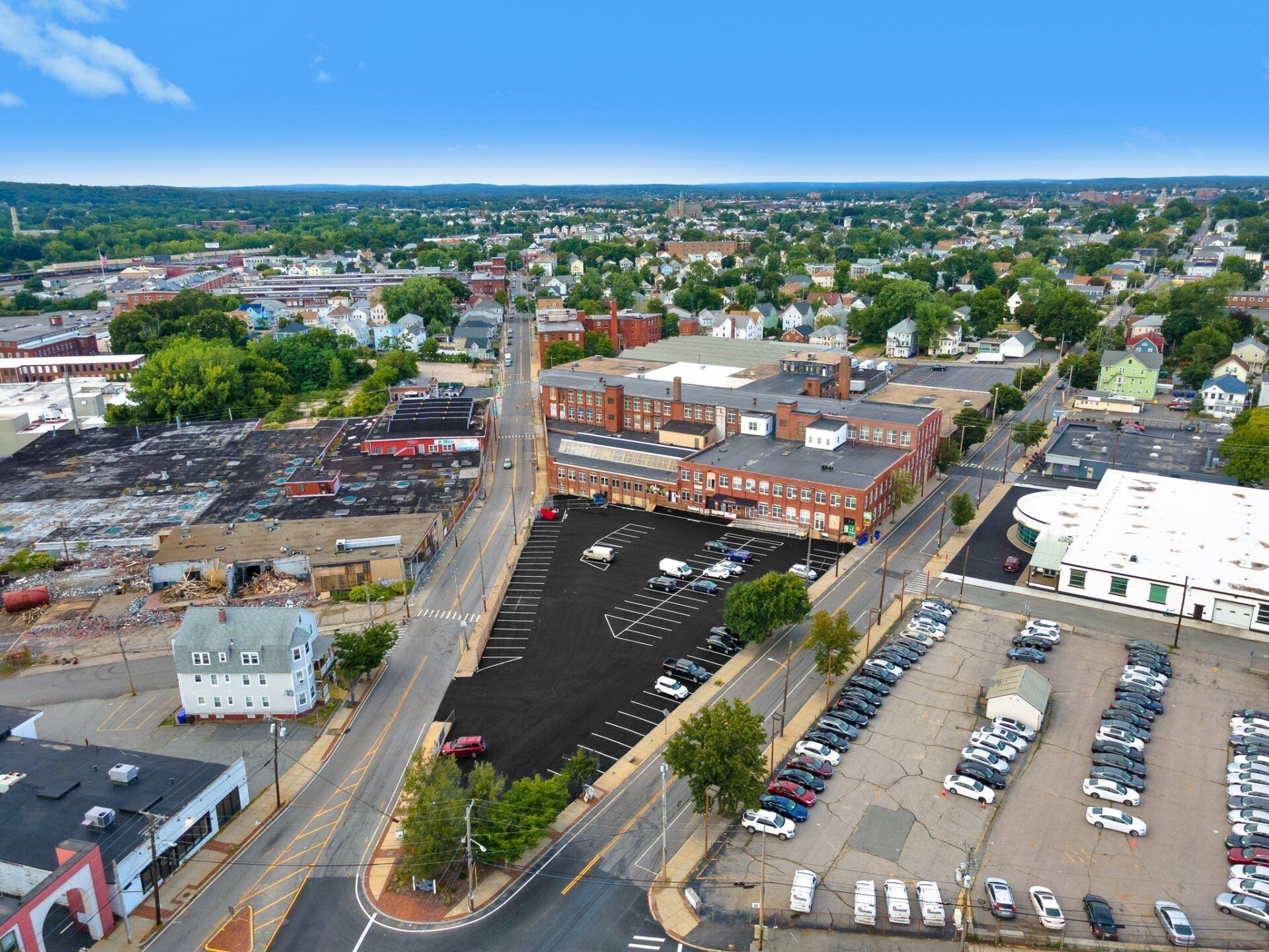 An aerial view of a city with a lot of cars parked on the side of the road.