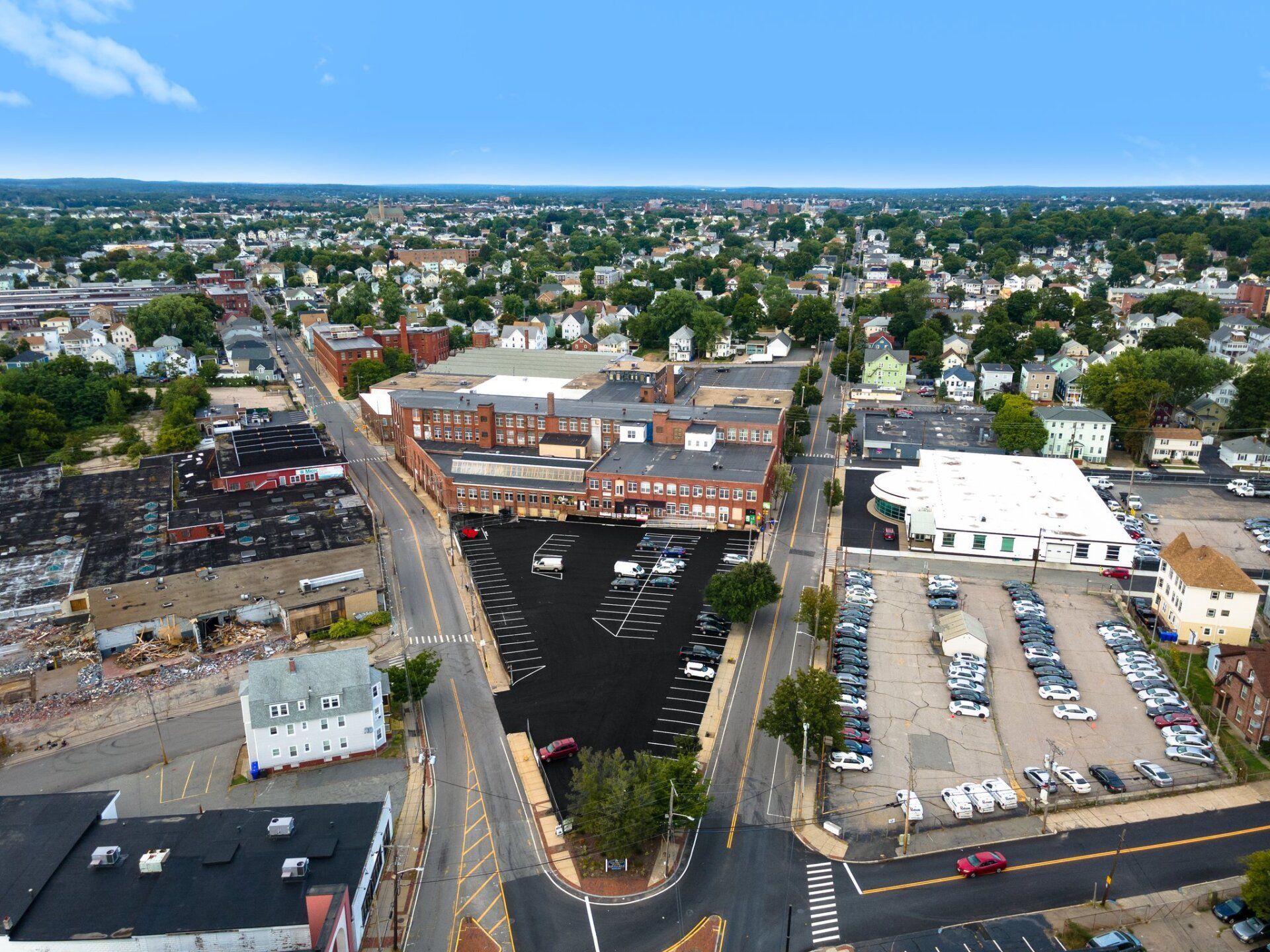 An aerial view of a city with lots of buildings and parking lots
