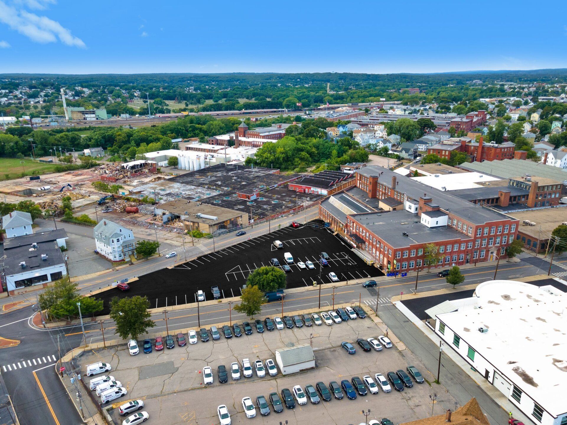 An aerial view of a city with a lot of cars parked on the side of the road.