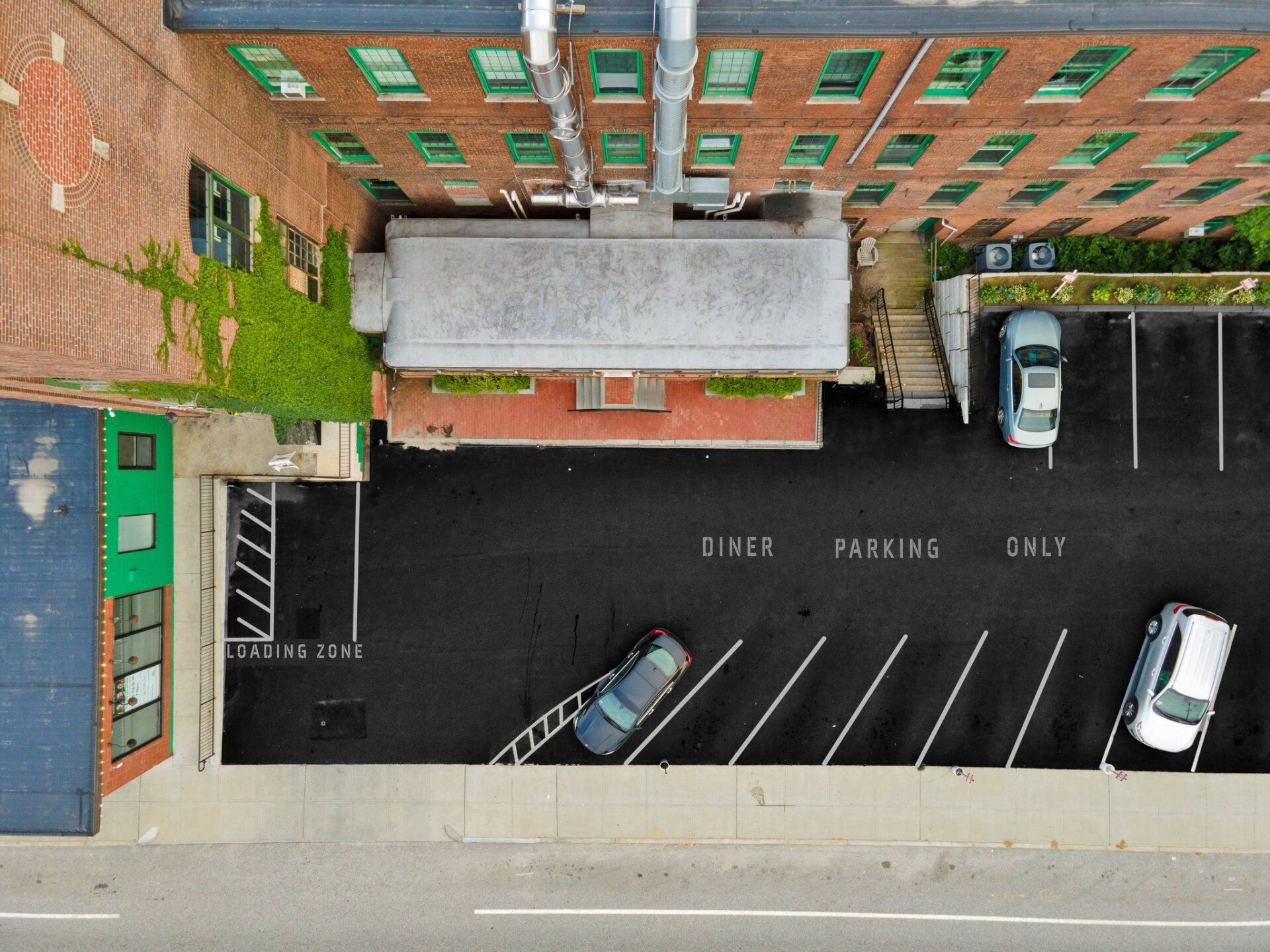 An aerial view of a parking lot in front of a building