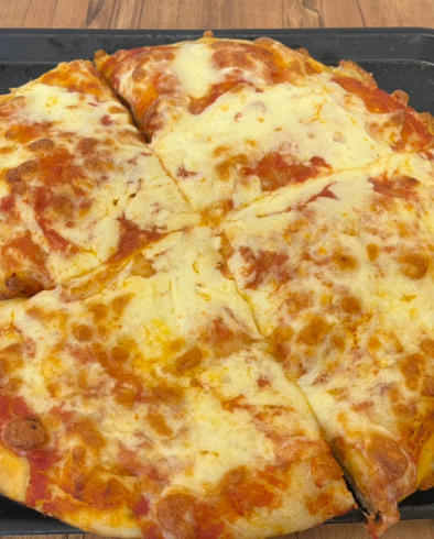 Una pizza con salsa di pomodoro e formaggio è appoggiata su un vassoio su un tavolo.