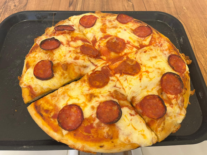 Una pizza al salame piccante con una fetta tolta