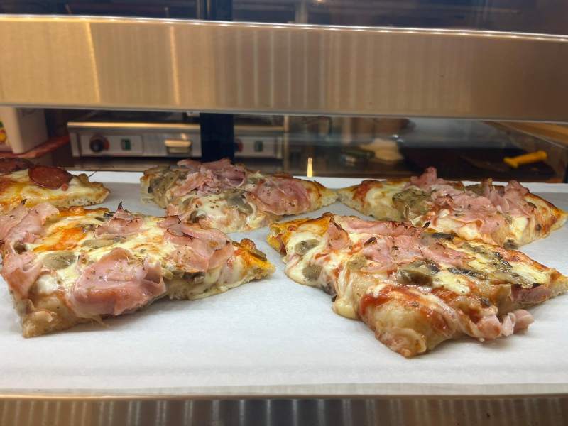 Diverse fette di pizza sono appoggiate su un tavolo