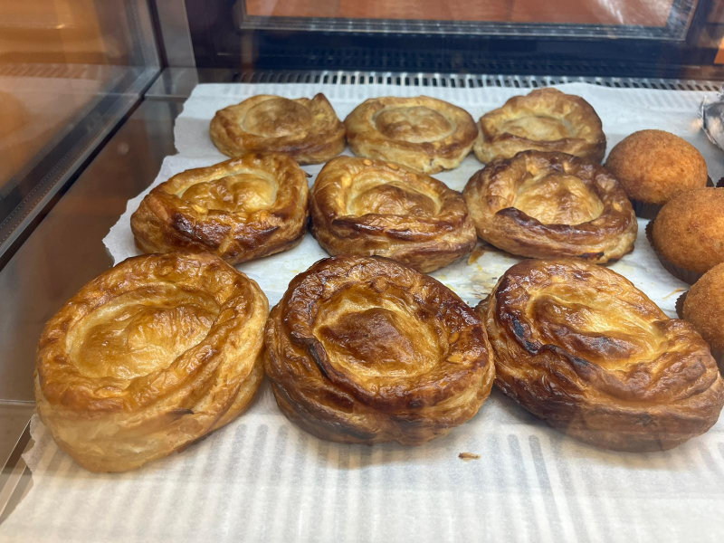 Un mucchio di pasticcini sono appoggiati su un tavolo in una panetteria