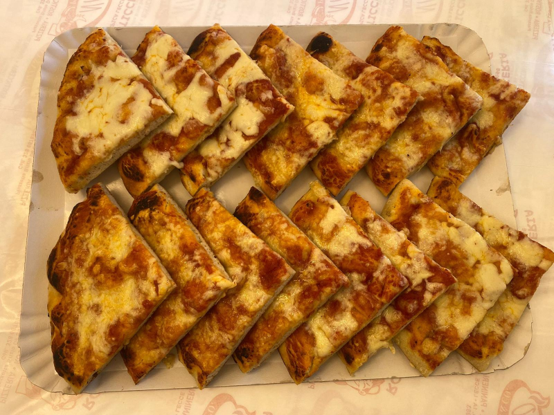 Un piatto di carta con sopra delle fette di pizza su un tavolo.