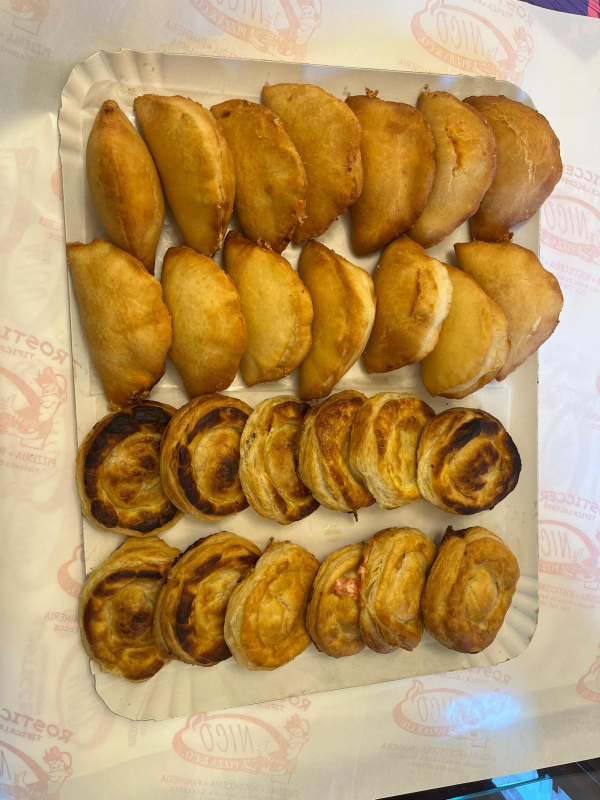 Un piatto di carta riempito con vari tipi di pasticcini su un tavolo.