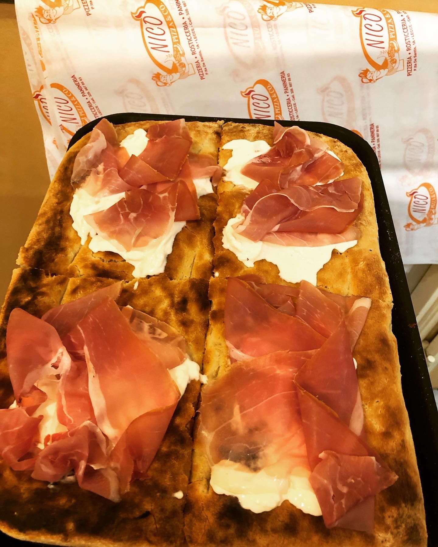 Una pizza con tanta carne e formaggio sopra