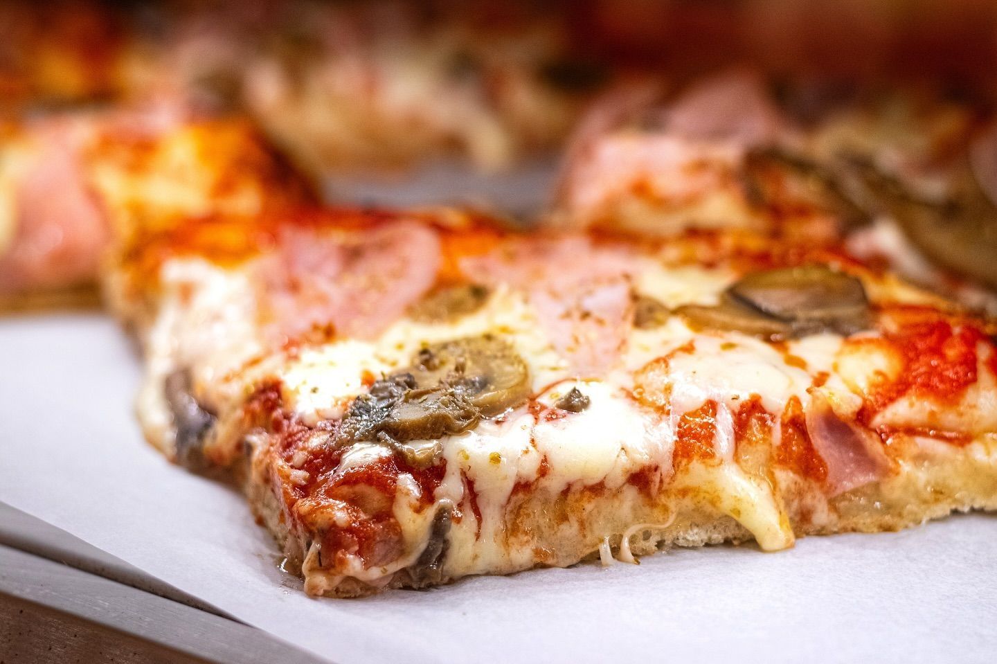 Primo piano di una fetta di pizza su un tavolo.