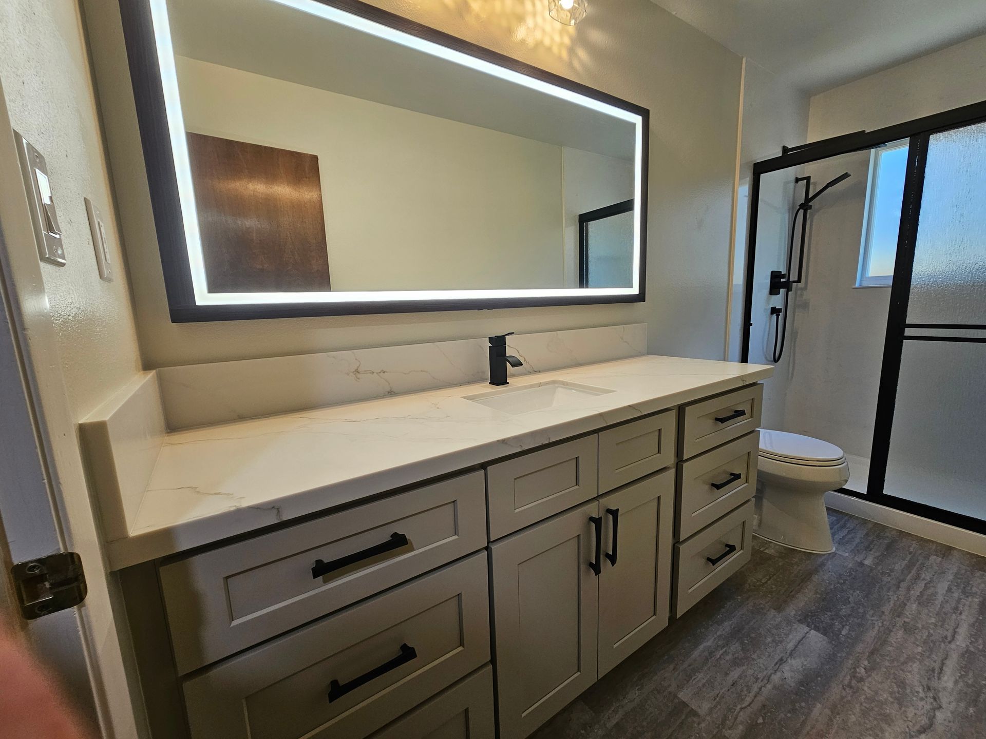 Bright modern kitchen with island seating, stainless fridge, and pendant lights