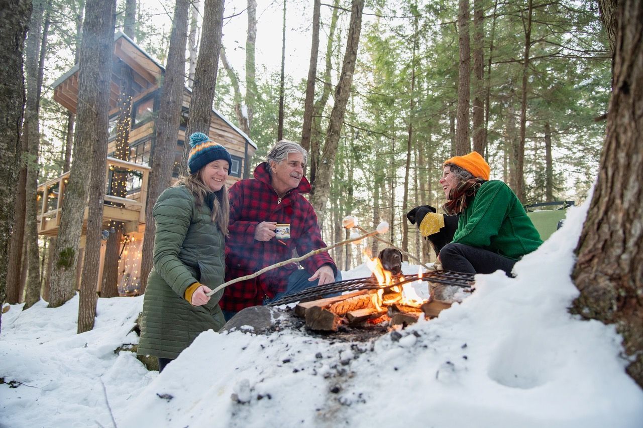 Three people enjoying a fire in the snow