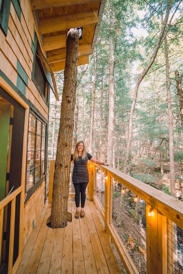 Heather Davis is standing on a deck next to a treehouse