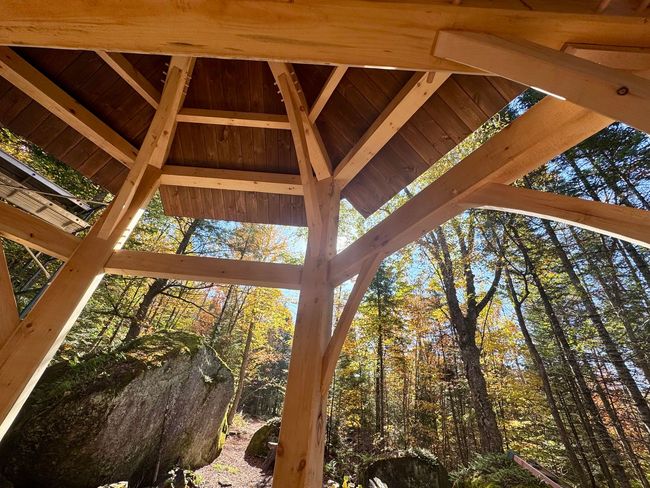 The timber frame of the future Crystal Chapel, in the forest with boulders