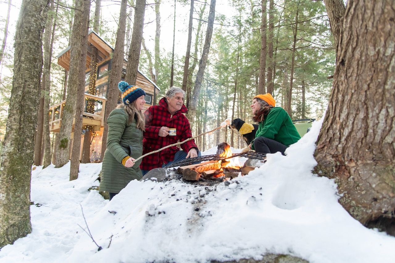 Three people enjoying a fire in the snow