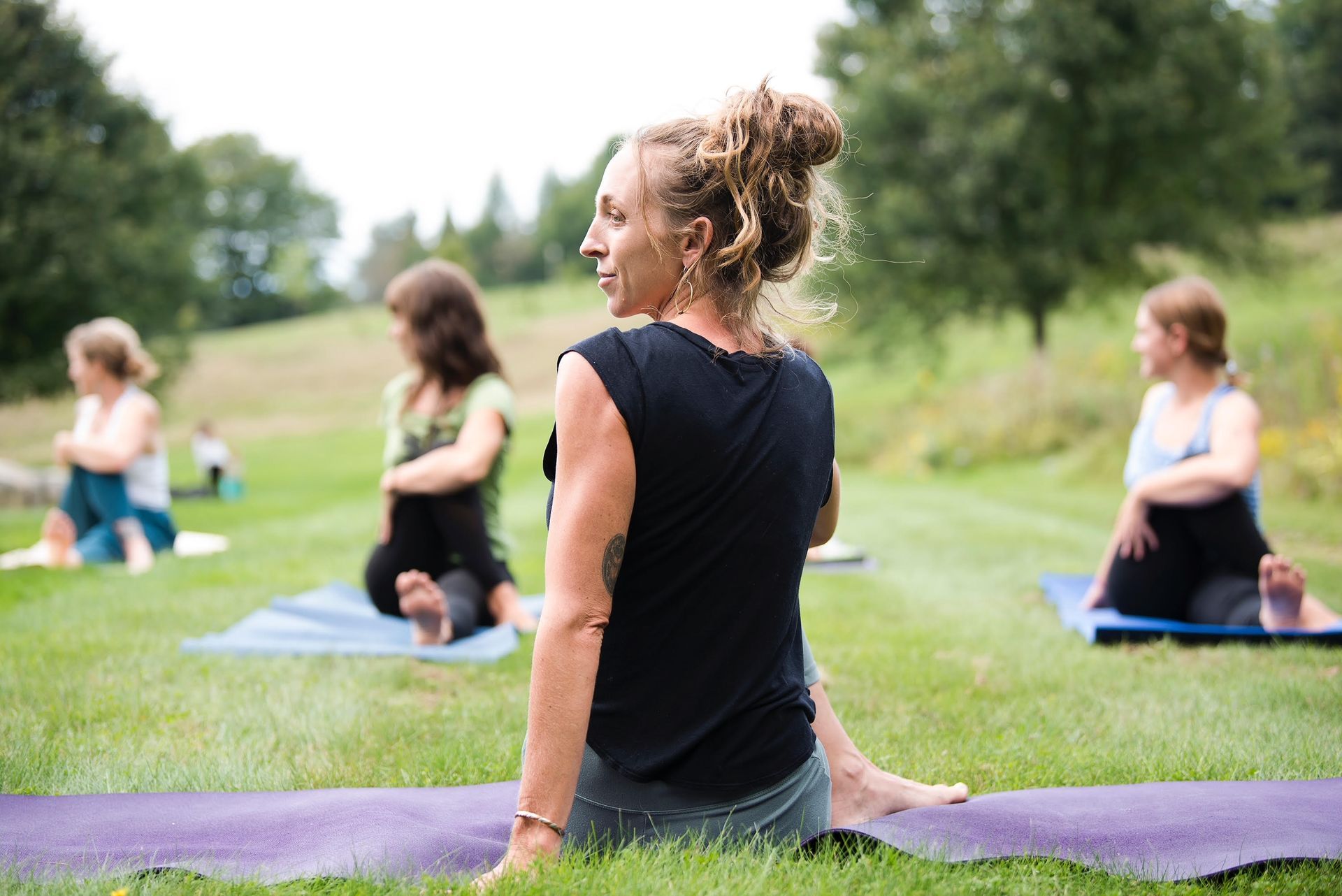 A women on a yoga mat outside in the summer