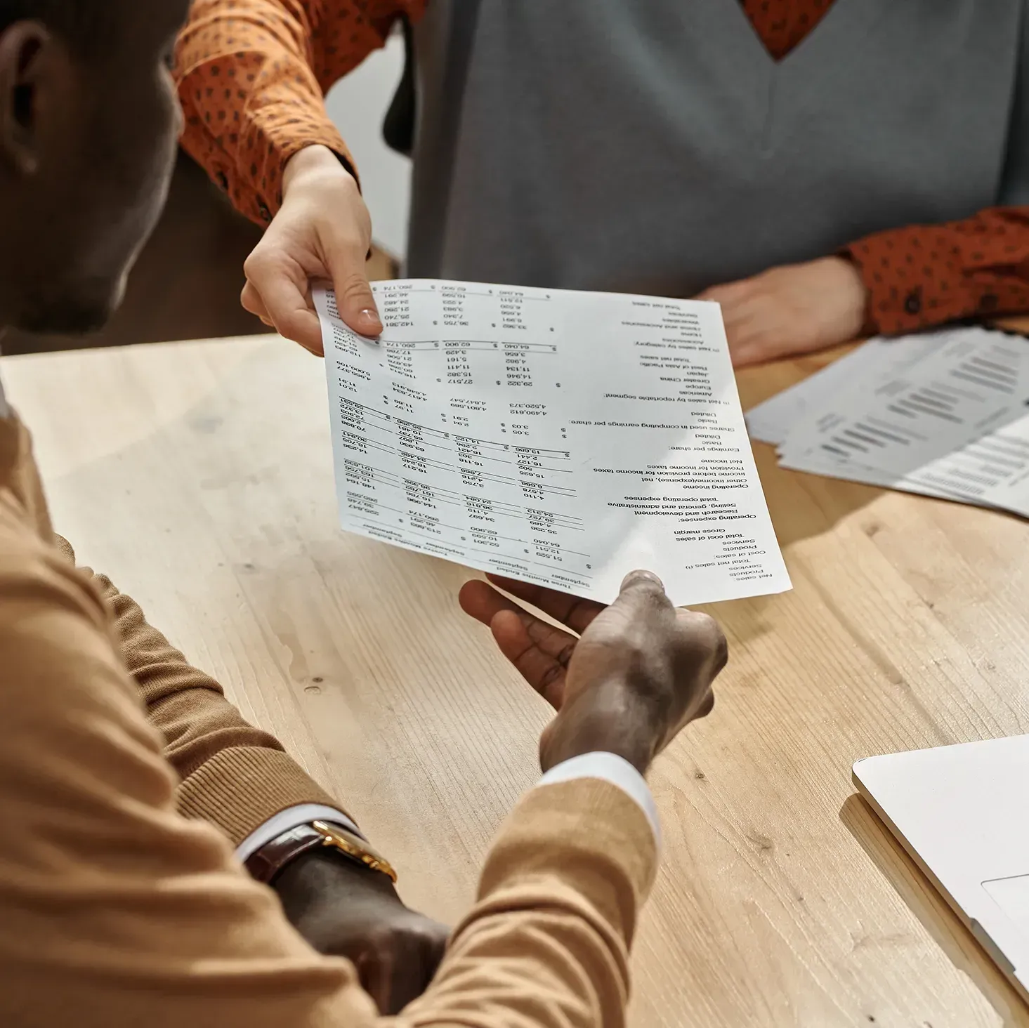 Accountant and client handing a piece of paper to each other