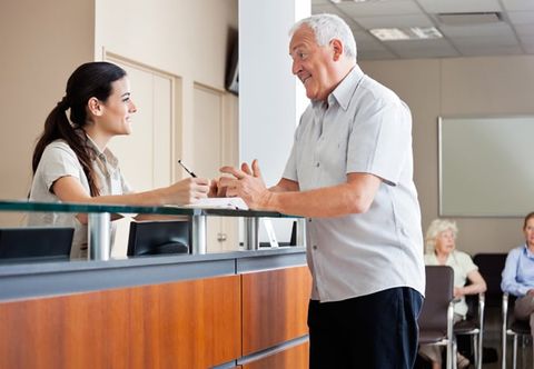 Man talking to receptionist at check-in