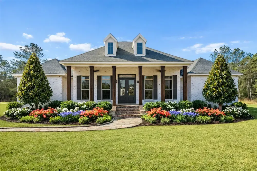 Southern‑style brick home in Lafayette, LA landscaped Teddy Bear Magnolias.