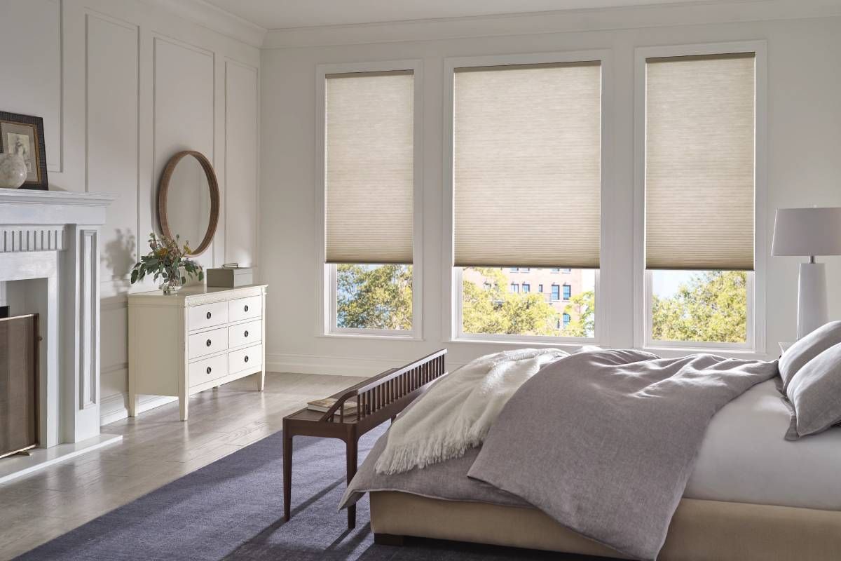 Chic Hunter Douglas Duette® Cellular Shades on three windows, partially lifted, in a bedroom