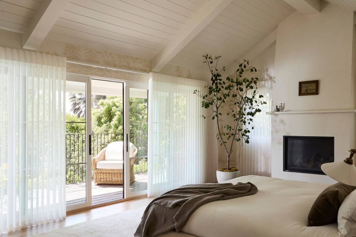 Hunter Douglas Luminette® Sheer Panels on windows and a sliding door in a bedroom
