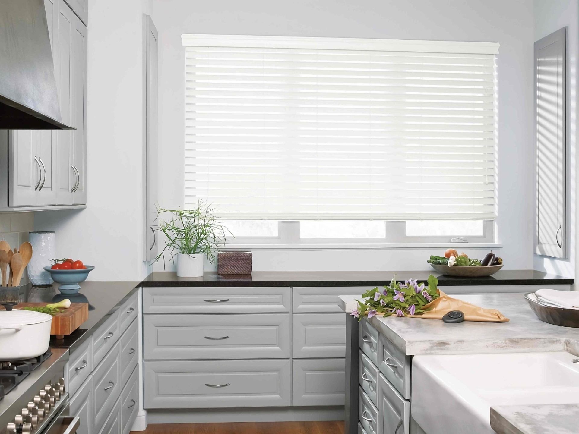 EverWood® Faux Wood Blinds in a contemporary kitchen with a black Pebble® Remote on the counter at Rachel Brosky Interiors near Elizabethtown, Kentucky (KY)